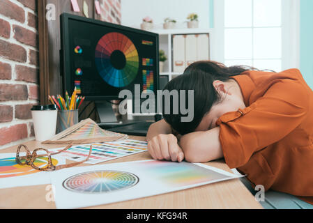 Graphiste de faire professionnel élégant nouveau design de produit une sensation de fatigue dans le bureau et s'appuyant sur un bureau de travail au repos du sommeil. Banque D'Images