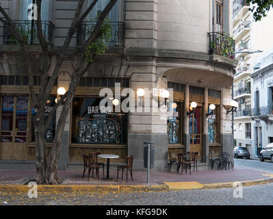 Tables vides en face de vieux traditionnels locaux, bar San Telmo, à Buenos Aires. Globes lumineux sur les vieilles portes en bois et de la rue vide. Banque D'Images