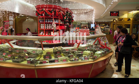 Clients mystères de Bariloche, Argentine, célèbre boutique de chocolat essayant de décider lequel d'acheter des chocolats de noël. shop orné de décoration rouge et vert Banque D'Images