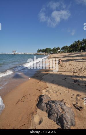 Un garçon admire la vue sur la mer sur une plage, le Strand, Townsville, Queensland, Australie Banque D'Images