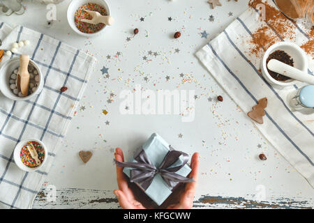 Femme tenant en mains cadeau de Noël avec ruban bleu. xmas concept. vue d'en haut. Banque D'Images