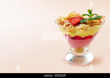 Dessert aux fraises dans des verres sur fond rose Banque D'Images