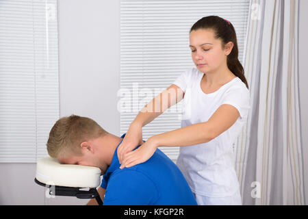 Photo de masseur pour femme l'épaule de l'homme massage Banque D'Images