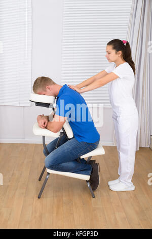 Photo de masseur pour femme l'épaule de l'homme massage Banque D'Images