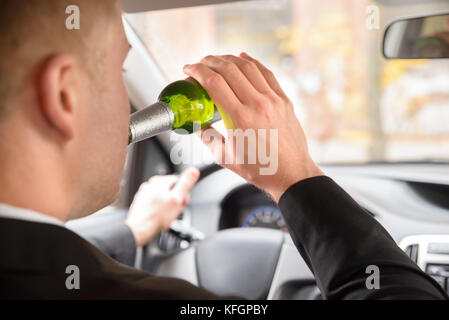 Close-up of Man Drinking Beer au volant d'un véhicule Banque D'Images