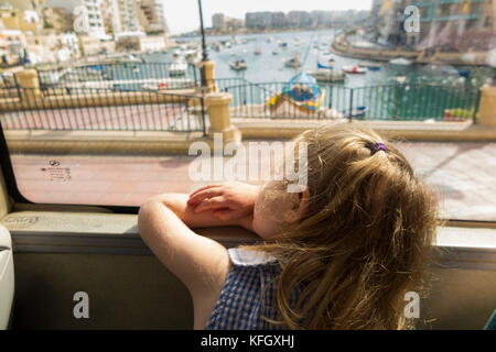 Trois ans, fille / enfant / passager / passagers voyageant sur un bus public / en utilisant les transports publics à St Julians Bay / Malte St Julian's Bay. Banque D'Images