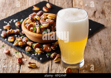 Verre de bière légère avec entrée de salé frit croustillant fèves close-up sur la table horizontale. Banque D'Images