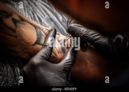 Mains de l'artiste de tatouage de la peau de l'homme Banque D'Images