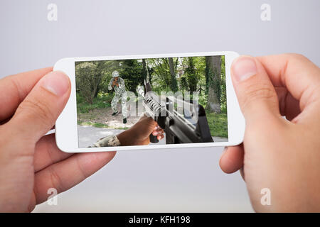 Gros plan du jeu d'action de l'homme jouant sur smartphone Banque D'Images