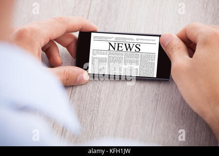 Portrait of businessman surfing news sur smartphone à 24 Banque D'Images