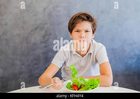 Cute teen boy n'aimez eating salad Banque D'Images