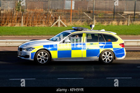 Une voiture de police BMW d'Écosse avec des feux bleus clignotant rapidement le long de la route à double voie répondant à un appel d'urgence 999 à Dundee, en Écosse Banque D'Images