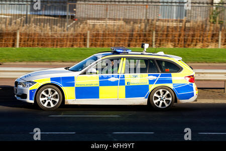 Une voiture de police BMW d'Écosse avec des feux bleus clignotant rapidement le long de la route à double voie répondant à un appel d'urgence 999 à Dundee, en Écosse Banque D'Images