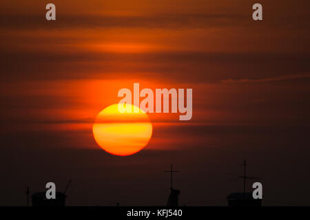 Jaune énorme soleil se lève sur la ville Banque D'Images