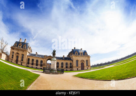 Photo fish-eye de grandes ecuries bâtiment avec statue équestre d'Henri d'Orléans en premier plan, château de Chantilly, France Banque D'Images