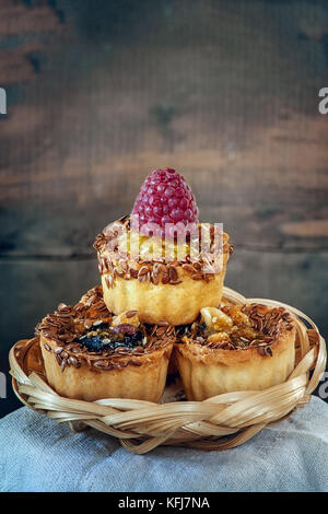 Délicieux petits muffins à la citrouille, décoré avec le caramel, le lin et les framboises. Copier l'espace. Banque D'Images