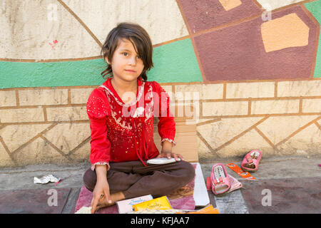 Téhéran, Iran - Août 16, 2017 Une petite fille petits paquets de tissus à la vente trottoir de la rue Banque D'Images