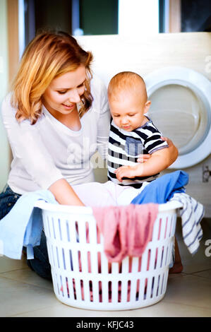 Jeune maman avec un petit garçon à faire des travaux ménagers. Banque D'Images