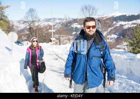 Couple de randonneurs explorer la montagne enneigée sur une journée ensoleillée Banque D'Images