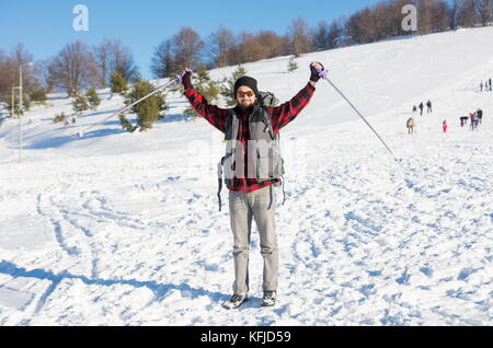 Male hiker avec sac à dos sur la montagne couverte de neige Banque D'Images