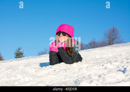 Jeune fille portant sur la montagne couverte de neige en veste de ski Banque D'Images