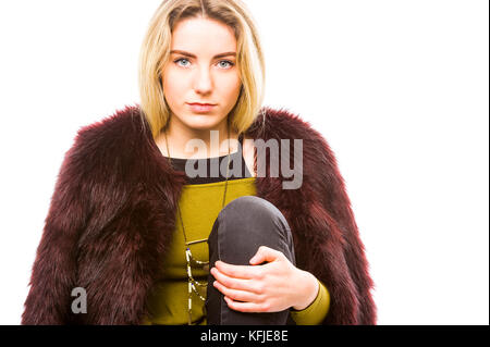 High key portrait de jeune fille, vue de face, tenant de la jambe, à la recherche directement à l'appareil photo. Copier l'espace. Banque D'Images