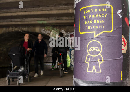 Affiche d'art de rue accrochée sur une colonne près d'un tunnel de l'artiste SUBDUDE avec un homme stylisé et un dessin animé avec le slogan "votre droit à la vie privée a été révoqué". Banque D'Images