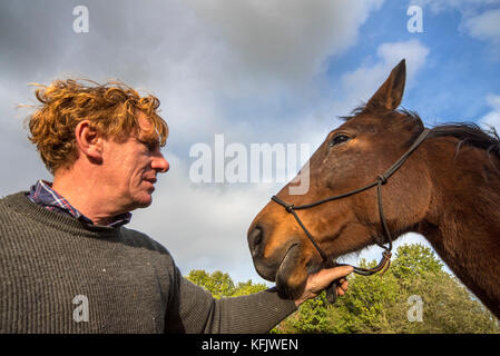 Close up portrait of horse whisperer / l'équitation naturelle cheval warmblood praticien holding Brown en plein air Banque D'Images