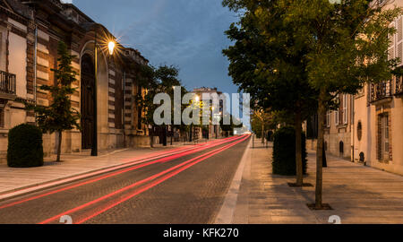 Avenue de champagne avec plusieurs maisons de champagne le long de la route pendant la nuit et la voiture avec les feux rouges à Epernay, France. Banque D'Images