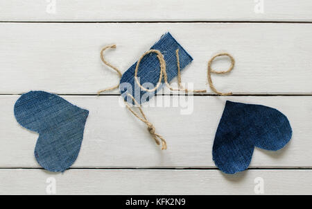 L'inscription originale de la vente de ficelle dans ma main et le jeans prix tag entre les deux coeurs bleu blanc sur fond de bois de storefront d Banque D'Images