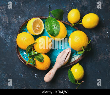 Citrons fraîchement cueillis avec des feuilles en bleu plaque en céramique Banque D'Images