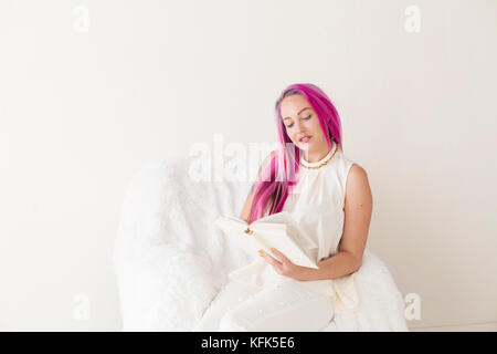 Belle jeune fille aux cheveux roses se lit le livre Éducation Banque D'Images