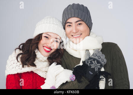 Smiling young asian couple portant en écharpe, sur fond gris Banque D'Images