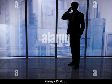 Toute la longueur du businessman using cell phone in office Banque D'Images