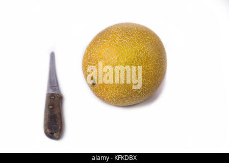 Melon cantaloup ou jaune sur fond blanc à l'aide d'un couteau Banque D'Images