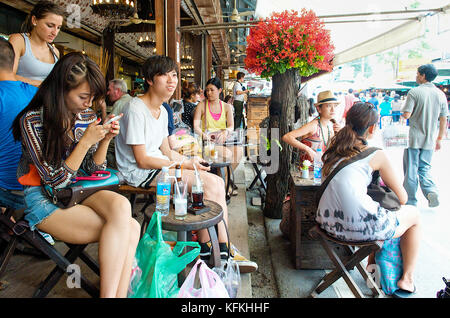 Les touristes prendre un verre dans un café branché de la célèbre à Bangkok Chatuchak Weekend Market, la Thaïlande, l'Asie du sud est. Banque D'Images