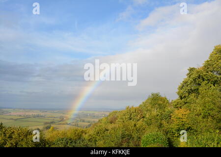 Un arc-en-ciel en automne ciel bleu dans la campagne du sud de l'Herefordshire en regardant du côté de la colline avec des nuages arbres et d'autres végétation de climat de temps Banque D'Images