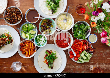 Enveloppements fait maison dîner avec des amis variété de salades Banque D'Images