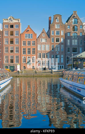 Amsterdam, Pays-Bas - 19 août, 2017 ; quatre de différents styles de façades architecturales pour laquelle ville est connue de l'autre côté du canal snd reflètent dans Banque D'Images