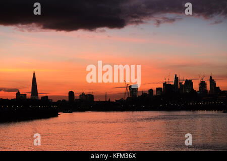 Londres, Royaume-Uni. 30th octobre 2017. Le magnifique coucher de soleil à travers la City de Londres éclairant les bâtiments emblématiques qui ont récemment surgi à Londres et la grande quantité de grues en tour de construction créant encore plus de gratte-ciel. La photo est prise de la rive de la rivière à Canary Wharf. Credit: Nigel Bowles/Alamy Live News Banque D'Images