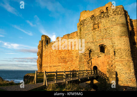 East Lothian, Scotland, UK. Dépression chaude du soleil crépuscule sur mur rideau de 14e siècle détruit le Château de Tantallon, falaise, dans le Firth of Forth près de North Berwick Banque D'Images