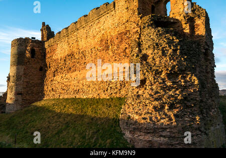 East Lothian, Scotland, UK. Dépression chaude du soleil crépuscule sur mur rideau de 14e siècle détruit le Château de Tantallon, falaise, dans le Firth of Forth près de North Berwick Banque D'Images