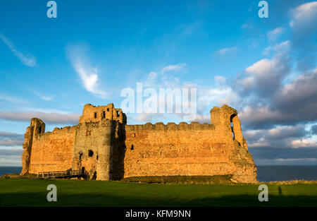 East Lothian, Scotland, UK. Dépression chaude du soleil crépuscule sur mur rideau de 14e siècle détruit le Château de Tantallon, falaise, dans le Firth of Forth près de North Berwick Banque D'Images