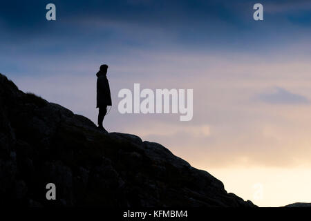 Silhouette - un homme solitaire silhouette sur la lumière du soir. Banque D'Images