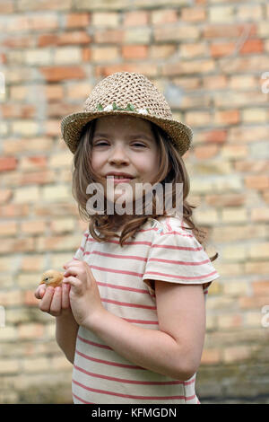 Happy little girl holding little chicken Banque D'Images