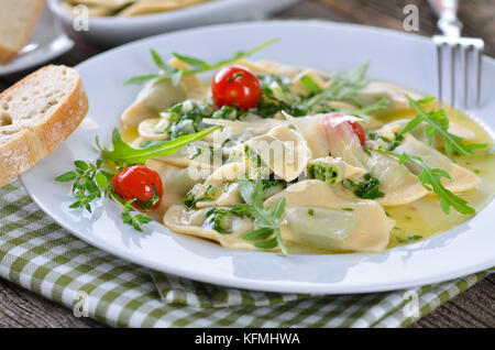 Les nouilles farci aux épinards et fromage blanc (une spécialité du Tyrol du Sud "chlutzkrapfen') servi avec sauce au beurre et rucola tomates cocktail Banque D'Images