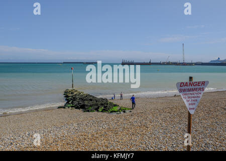 Dover, Kent, UK - 17 août 2017 : : plage à l'intérieur du port de Douvres avec épi. montre que les personnes profitant de la journée ensoleillée sur la plage. Banque D'Images