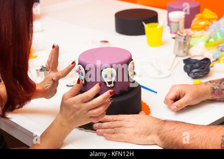 Leçon de pâtisserie, de travailler sur les chiffres de l'halloween avec du fondant pâte ou pâte à sucre. Banque D'Images