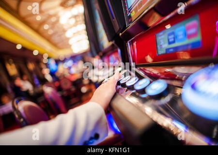 Casino slot jeux vidéo. woman playing video slot au casino. main sur le bouton pari photo gros plan. Banque D'Images