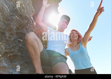 Portrait of happy couple standing on rock dirigés à l'écart Banque D'Images